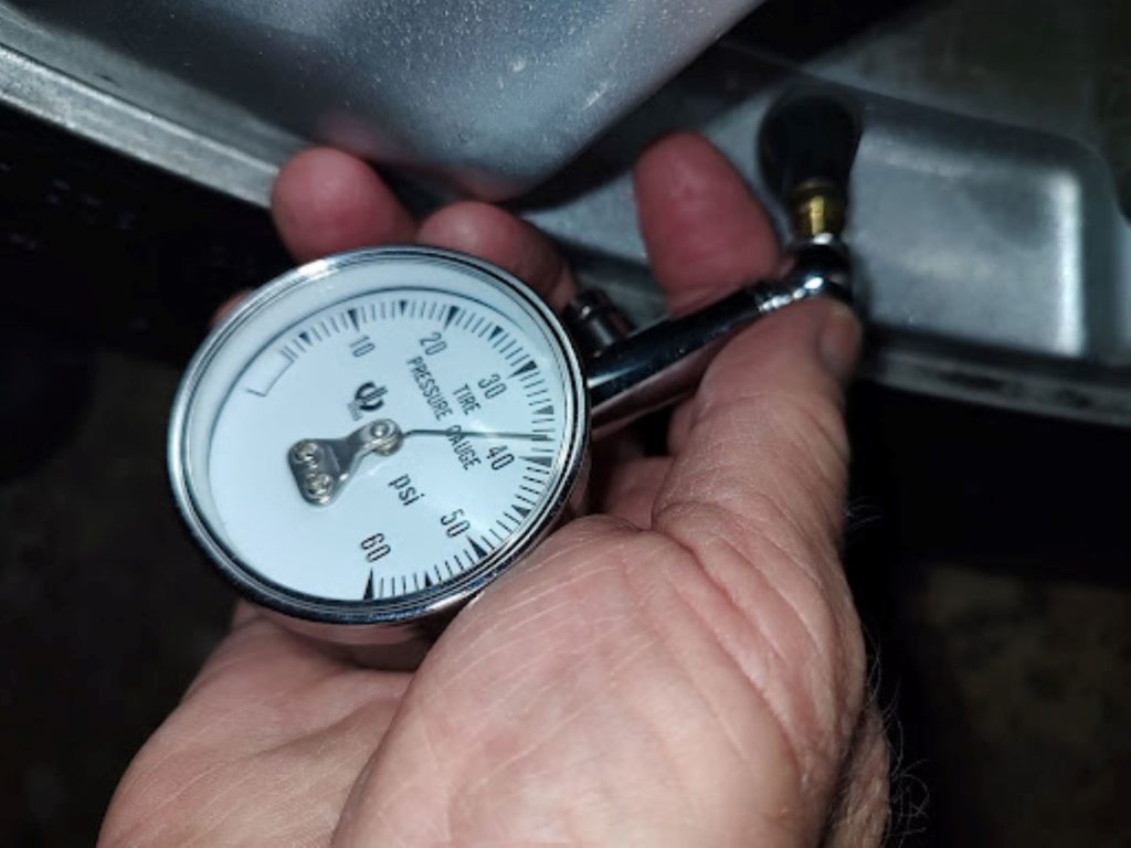 hand holding a car tire pressure gauge