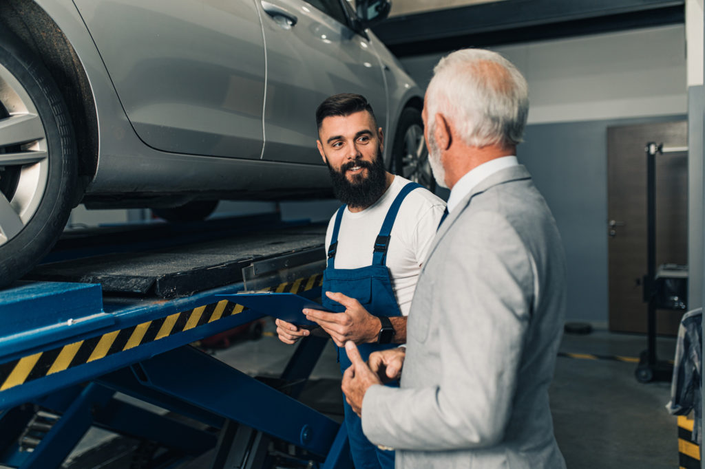 certified mechanic talking to a male car owner