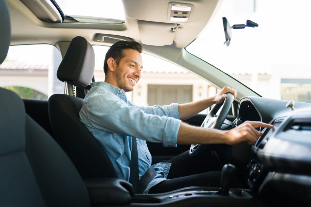 male in his 30s smiling while driving