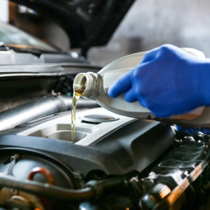 mechanic with gloves performing oil change