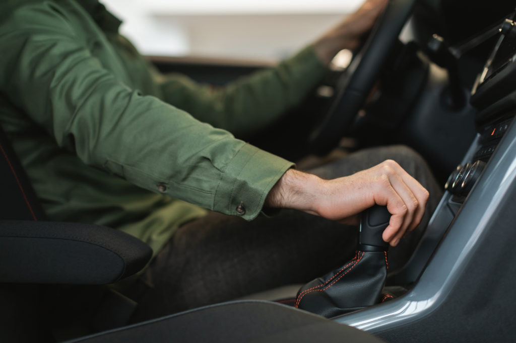 young guy driving a car with manual transmission