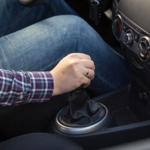 young man shifting manual transmission gearbox in car