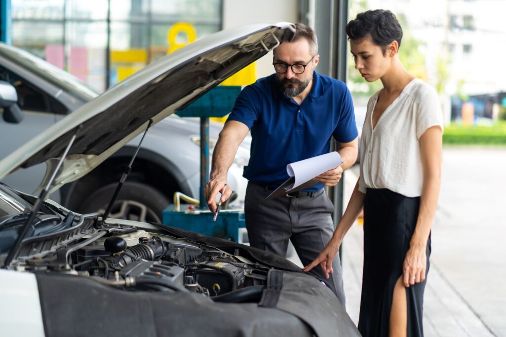 mechanic inspecting car with a female car owner