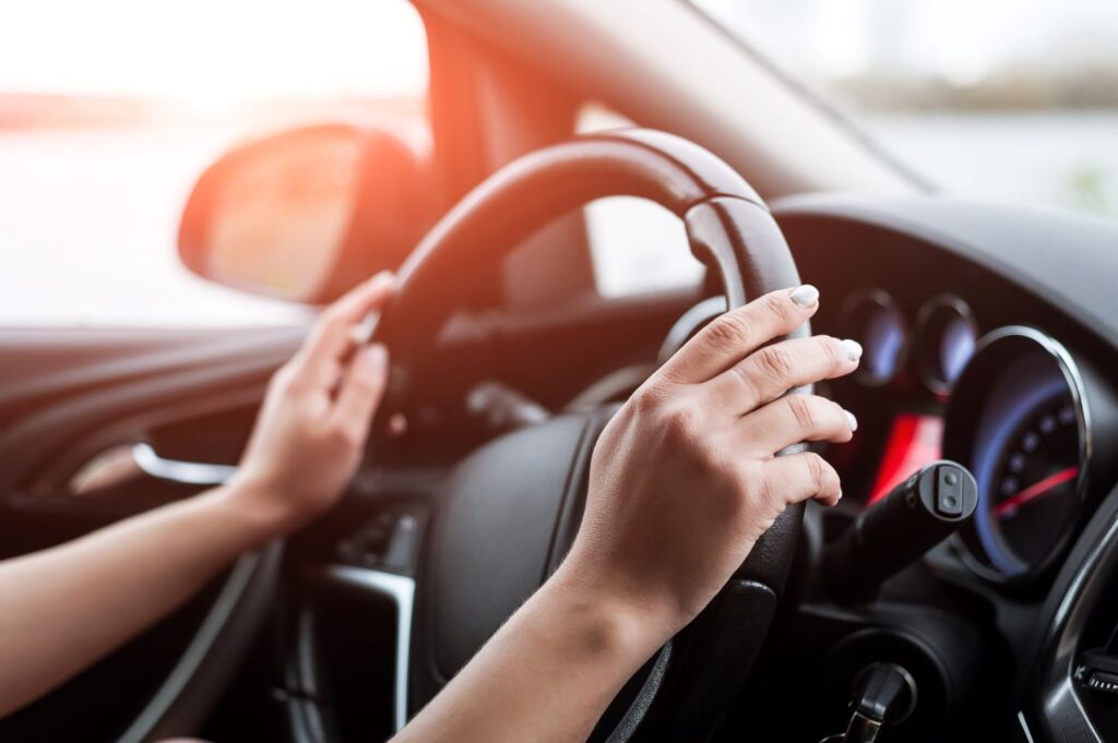 female hands on the steering wheel