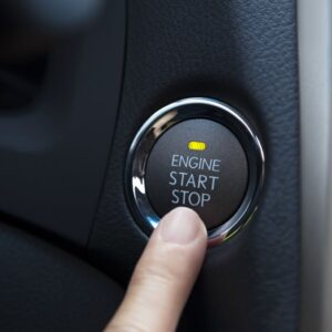 driver pressing the push start button