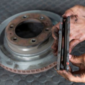 mechanic showing uneven brake pad wear