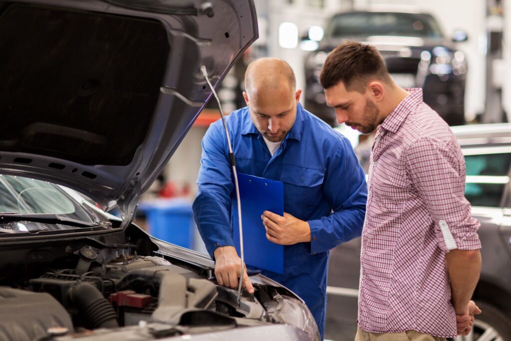 mechanic and car owner checking the engine