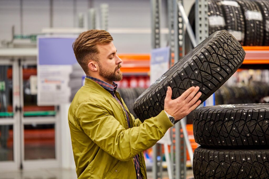 man buys new tire for his car