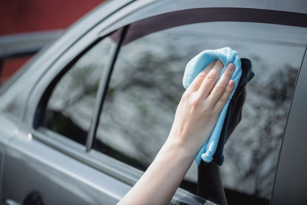 wiping car window using microfiber cloth