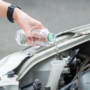 pouring water inside the car radiator to cool it down