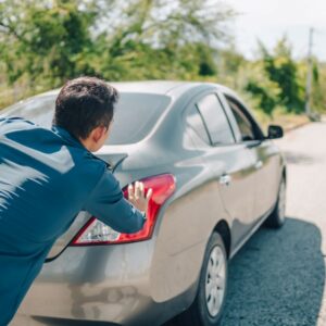 man pushing a car