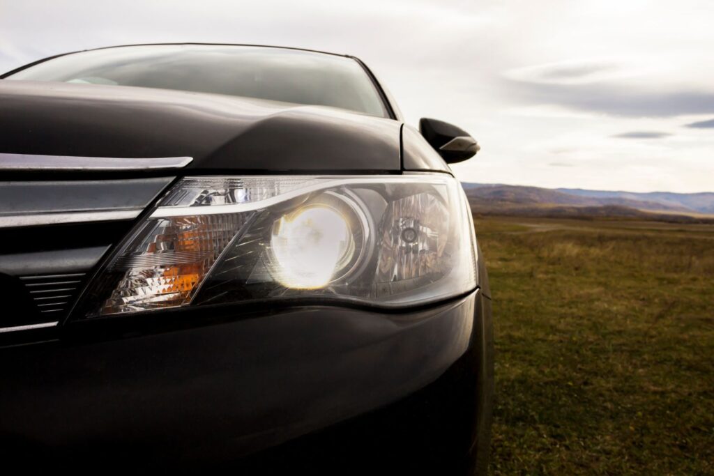 black sedan with illuminated headlights