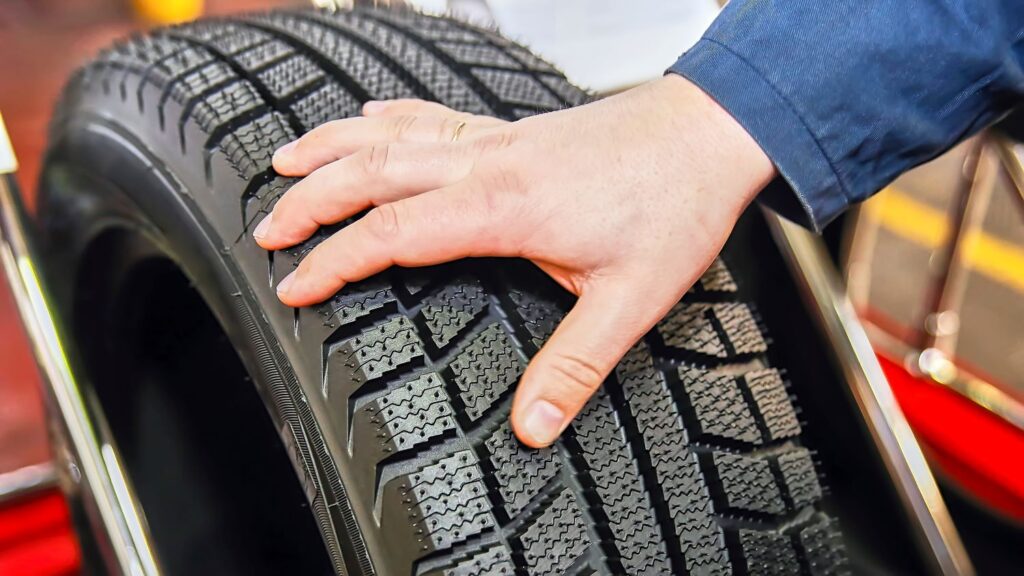 hand touching a new car tire