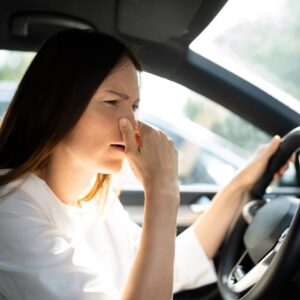 female driver smelling something bad in the car