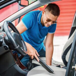 man cleaning stain on car seat