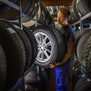 man picking new black tire