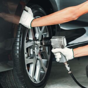 mechanic using a pneumatic tool to a wheel