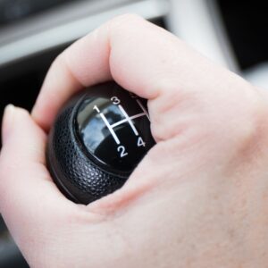 hand holding a manual shifting gear