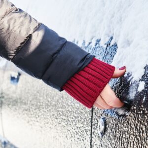 woman holding the handle of a frozen car door