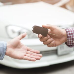 man handing car keys to another person