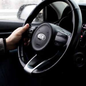 driver holding a kia steering wheel