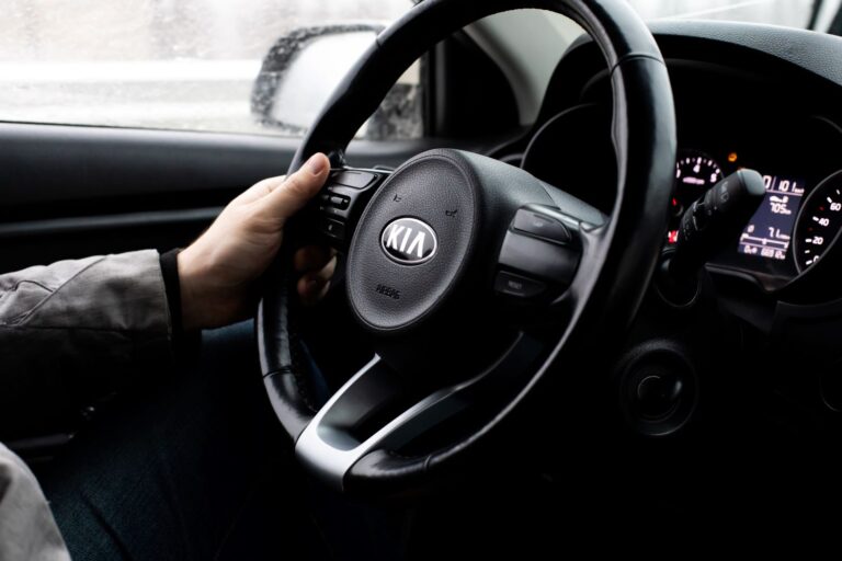 driver holding a kia steering wheel