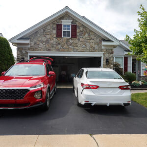 two cars in front of a home garage