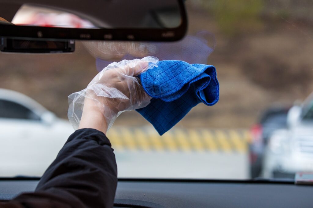 car driver cleaning windshield from inside