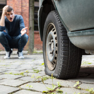 man finds his car tire flat