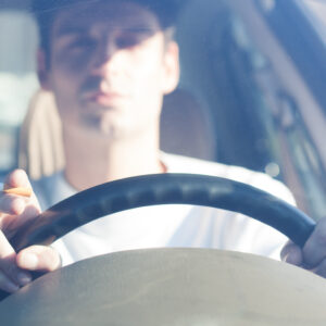 man driving with a cigarette