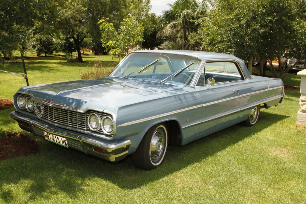 parked 1964 chevy impala- under a tree