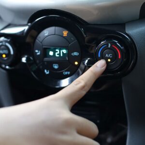 finger touching the car ac switch