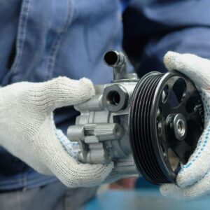 mechanic holding a power steering pump