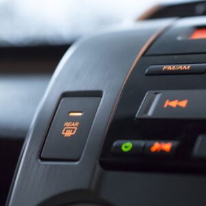 close up shot of a car rear window defroster button and infotainment buttons