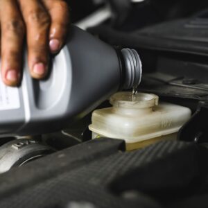 pouring brake fluid into a brake fluid reservoir