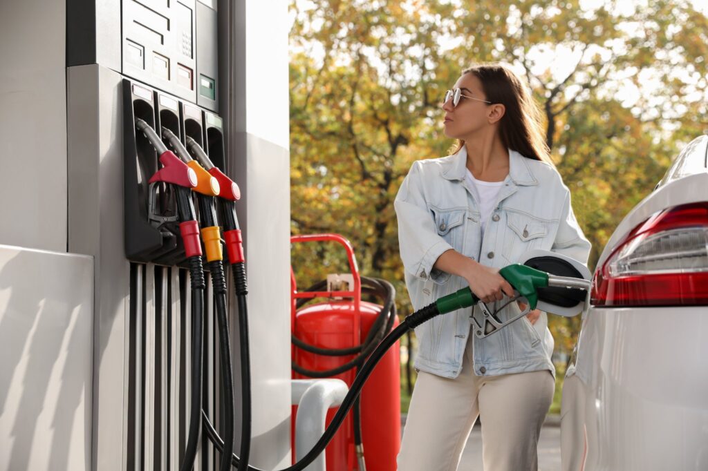 female driver refuel car gas tank on left side of car