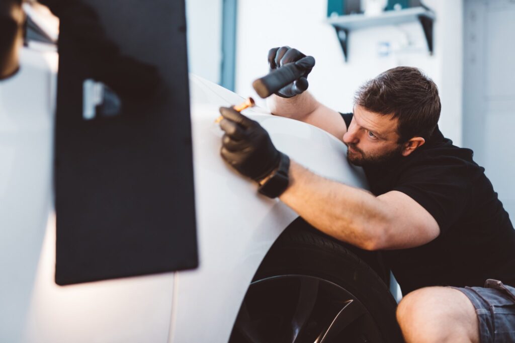 man performing paintless dent removal