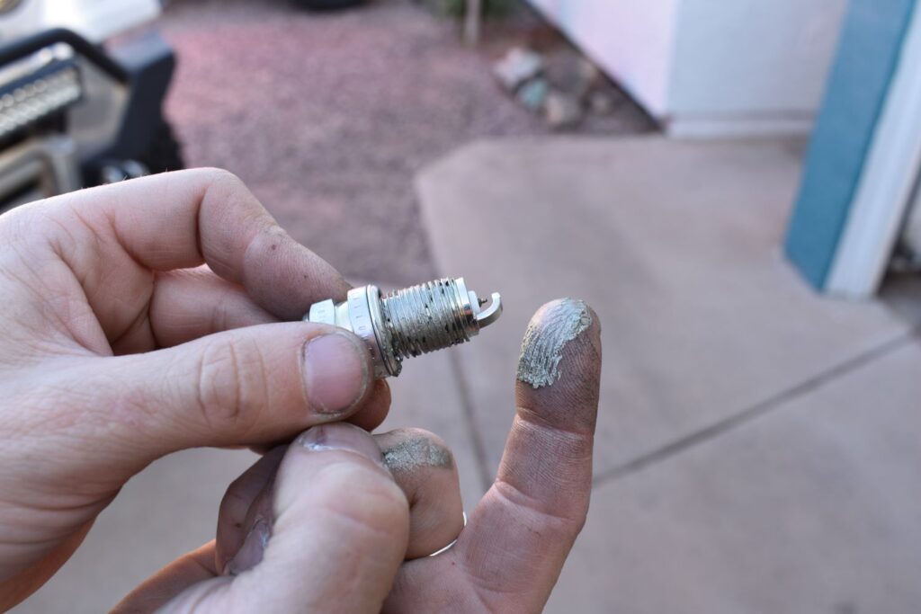 applying anti seize to a spark plug