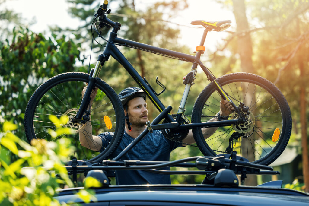 biker mounting his bike on a car bike rack