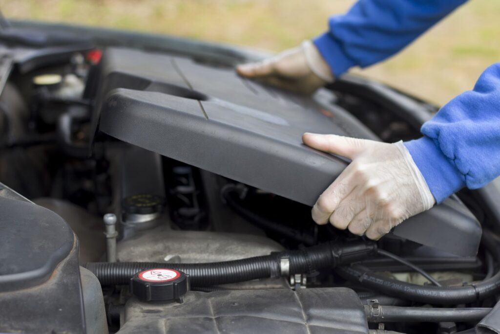 mechanic removing an engine cover