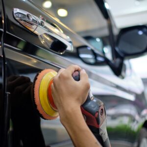 mechanic polishing car door panel