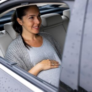 pregnant woman sitting inside a car