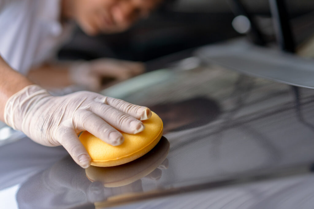 man waxing car