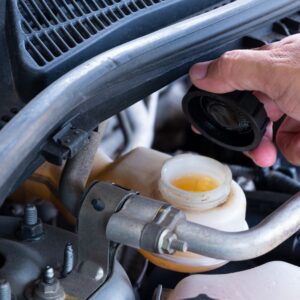 hand lifting the cap of a brake fluid reservoir