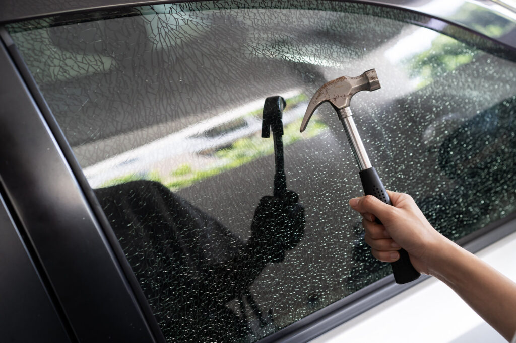 breaking a car window with hammer