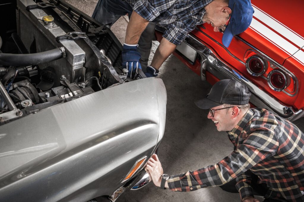 two guys doing classic car maintenance