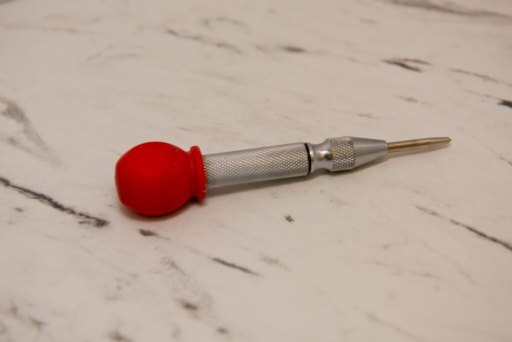 close up shot of an automatic center punch tool