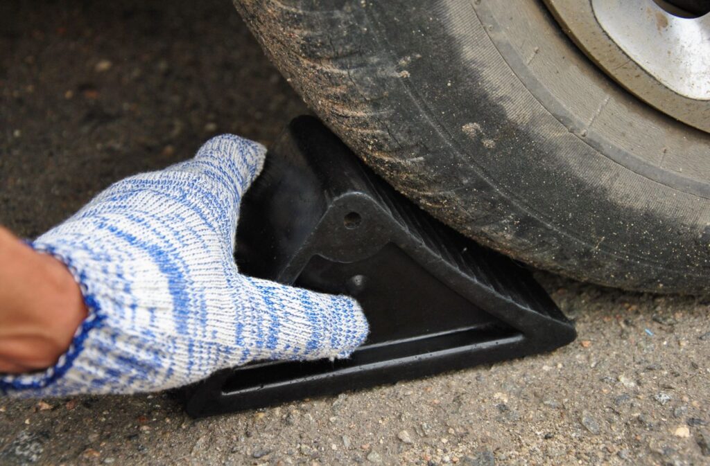 inserting a wheel chock beside a tire