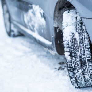 close up shot of snow tires on a snowy road