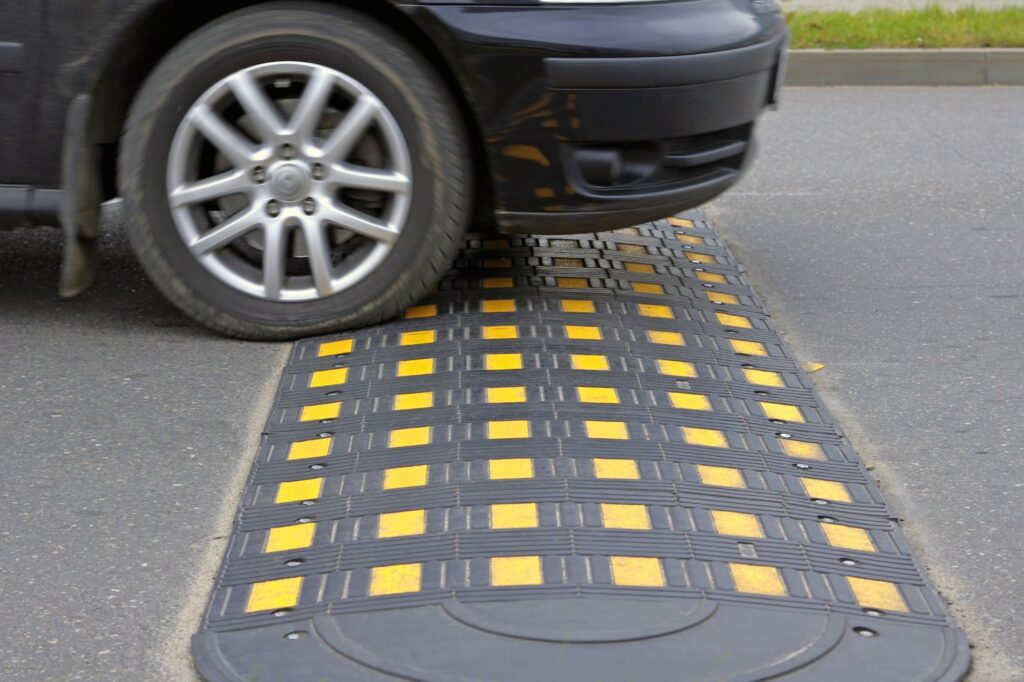 car passing a black speed bump